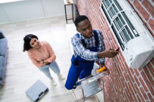 male air conditioning technician helping woman fix her indoor unit